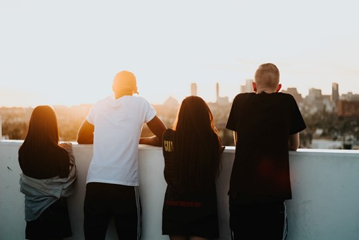 4 adolescents looking over city