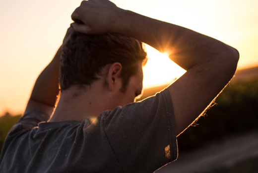 Person with hands holding back of the head looking